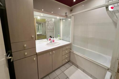 une salle de bain avec un lavabo, une baignoire et un miroir dans l'établissement Grand Appartement, idéal pour vous, en Hypercentre, à Troyes