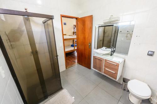 a bathroom with a shower and a toilet and a sink at Pousada Espaço Viagi in Taubaté