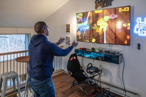 a man playing a video game on the nintendo wii at Luxurious Poconos Retreat - Hot Tub, Sauna, Games in East Stroudsburg