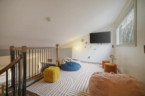 a room with a staircase with a bed and a tv at Luxurious Poconos Retreat - Hot Tub, Sauna, Games in East Stroudsburg