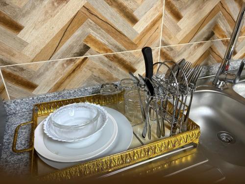 a tray with a plate and utensils on a sink at Luxury Two Bedroom Spacious Appartment Brand New in Ajman