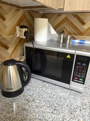 a microwave with a coffee pot on top of it at Luxury Two Bedroom Spacious Appartment Brand New in Ajman