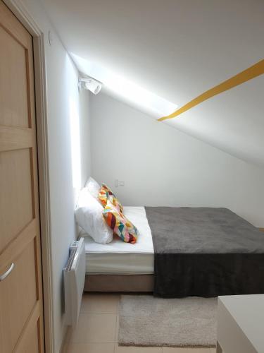 - un petit lit dans une chambre dotée d'un mur blanc dans l'établissement A04 Le Lounge - Clim- Wifi - Coeur de Ville, à Béziers