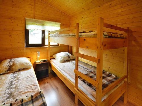 a bedroom with two bunk beds in a log cabin at Cottage in Rusinowo near Seaside Beach in Rusinowo