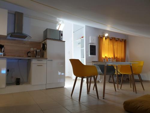 une cuisine et une salle à manger avec une table et des chaises dans l'établissement A04 Le Lounge - Clim- Wifi - Coeur de Ville, à Béziers
