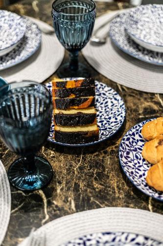 a table with plates of food and wine glasses at Hermes Modern Apartment in Alexandroupoli