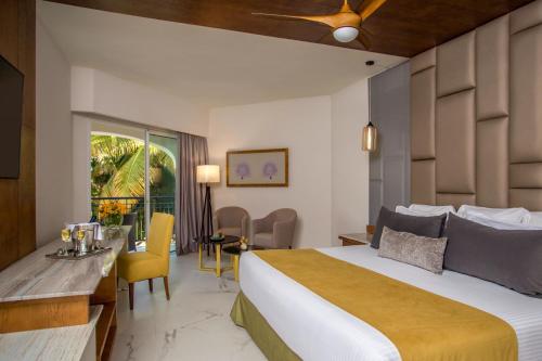a hotel room with a bed and a table and chairs at Secrets Royal Beach Punta Cana - Adults Only - All Inclusive in Punta Cana