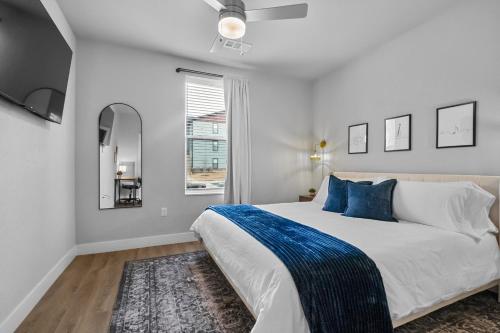 a white bedroom with a large bed and a window at Deluxe Apt, King Bed, Pool, Gym,free "p" in Rogers