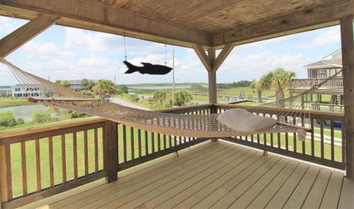 a hammock on a porch with a view of the ocean at Fooses Folly in Folly Beach
