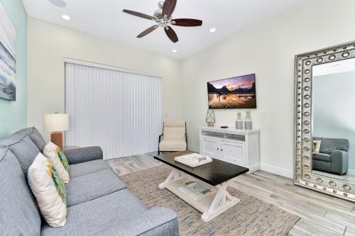 a living room with a couch and a mirror at Margaritaville Cottages Orlando with H2O Waterpark by Rentyl in Kissimmee