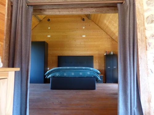 a bedroom with a bed with blue pillows at Eco-grange au milieu de notre ferme biologique O'Naturel in Massat