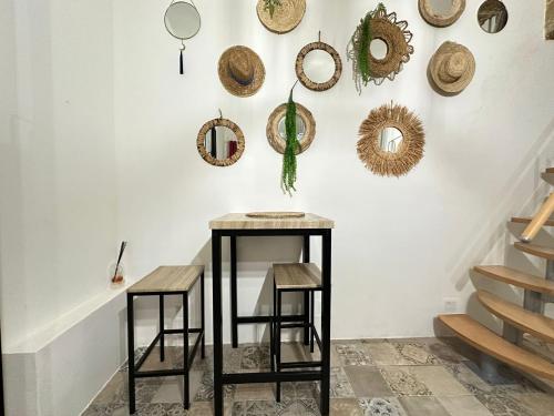 une table avec deux tabourets devant un mur avec miroirs dans l'établissement Appartement Centre Historique, à Montpellier