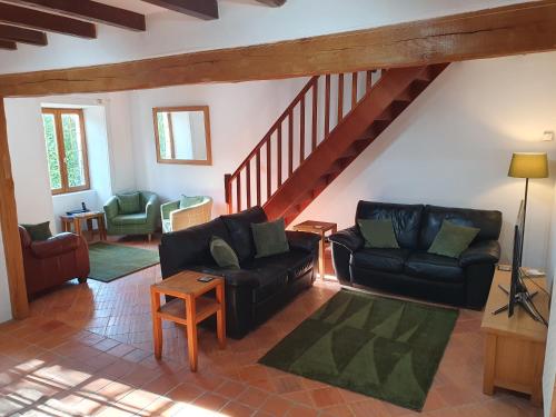 - un salon avec deux canapés et un escalier dans l'établissement Maison de l'olivier, à Champniers-et-Reillac
