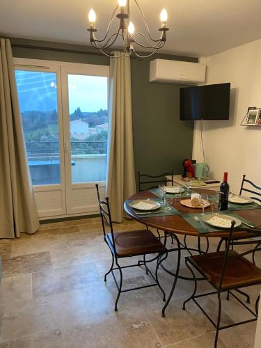 une salle à manger avec une table et des chaises et une fenêtre dans l'établissement Au pied des Alpilles, à Paradou
