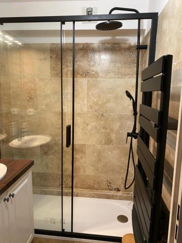 une douche avec une porte vitrée dans une salle de bain dans l'établissement Au pied des Alpilles, à Paradou