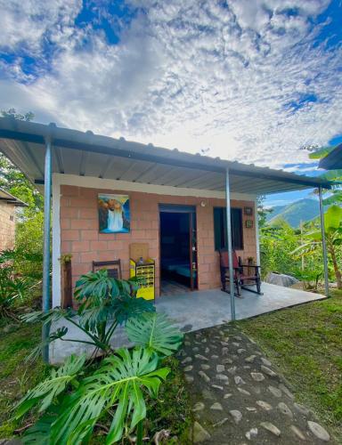 a small house with a porch with a roof at Pitalito - Mis Rokas Finca Campestre in Pitalito