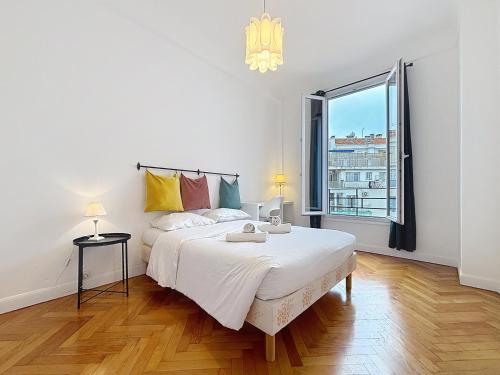 une chambre blanche avec un grand lit et une fenêtre dans l'établissement Nice Carlone Appart 6 pers, Clim, proche mer, transports, à Nice