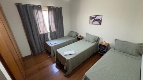 a room with two beds and a window at Casa de Temporada Umuarama in Uberlândia