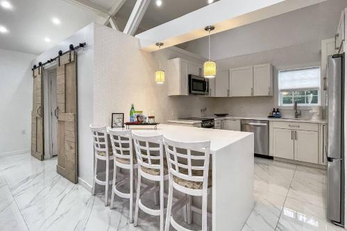 a kitchen with white cabinets and a bar with stools at Cozy Cottage in Cos Cob in Greenwich