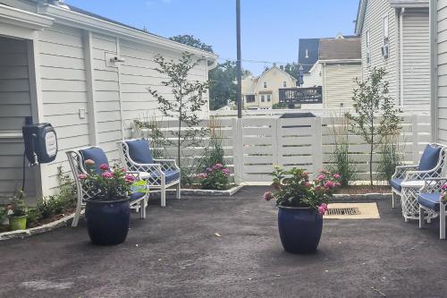 a patio with blue chairs and potted plants at Cozy Cottage in Cos Cob in Greenwich