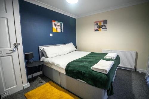 a bedroom with a bed with a green blanket at Couver House in Livingston