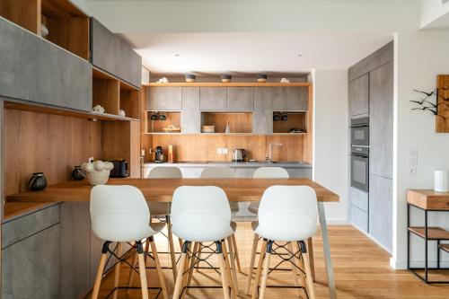 - une cuisine avec une table en bois et des tabourets blancs dans l'établissement Saint Victor, double terrasse vue sur le vieux port, à Marseille