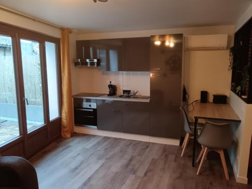 - une petite cuisine avec une table et un comptoir dans l'établissement La Fabrique, à Sainte-Livrade-sur-Lot