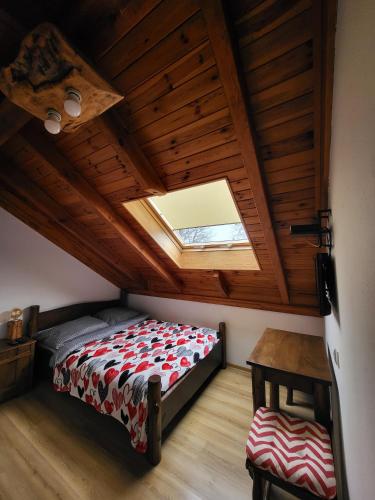a attic bedroom with a bed and a skylight at Hacjenda in Susiec
