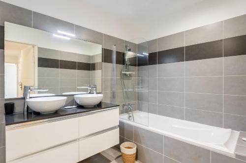 une salle de bain avec deux lavabos et une baignoire dans l'établissement Saint Victor, double terrasse vue sur le vieux port, à Marseille