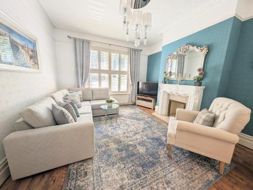 a living room with two white couches and a fireplace at South Coast Seaside Holiday Home -3 BED-GF-Sleeps 8-Free Parking-Walk to Beach-Private Garden- Families-Professional Groups-Contractors WELCOME in Bournemouth