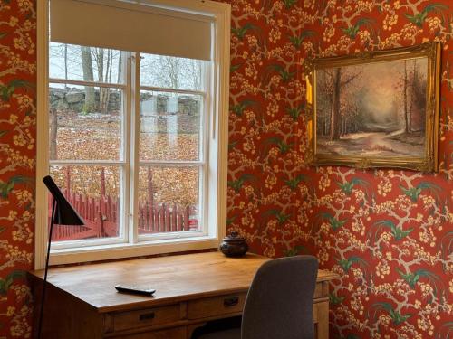 a desk with a window in a room with wallpaper at Hishult No 5 Hishults Prästgård in Hishult