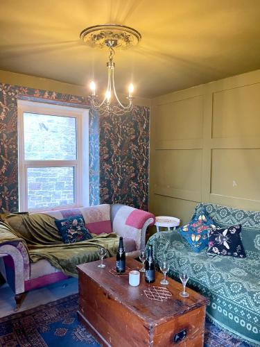 a living room with a couch and a table at Cheviot House Gallery And Guest Rooms in Wooler