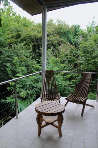 two benches on a porch with a view of trees at Nosara Verde in Nicoya