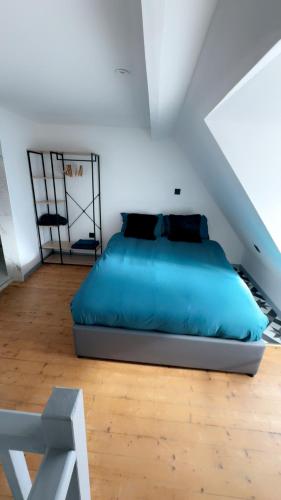 - une chambre mansardée avec un lit bleu dans l'établissement Le Gris métal, T2 duplex, centre ville historique, à Bourges