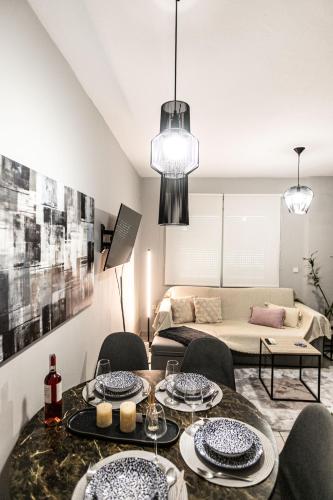 a living room with a table and chairs and a couch at Hermes Modern Apartment in Alexandroupoli