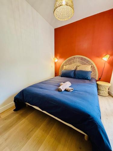 une chambre avec un grand lit bleu avec un mur rouge dans l'établissement TERRAVITA - Bel Appartement - Calais Centre, à Calais