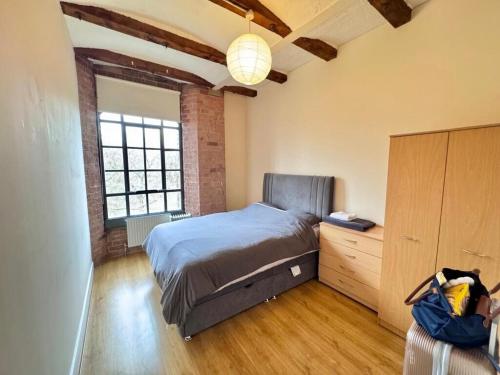 a bedroom with a bed and a dresser at William Bancroft Apartment in Nottingham