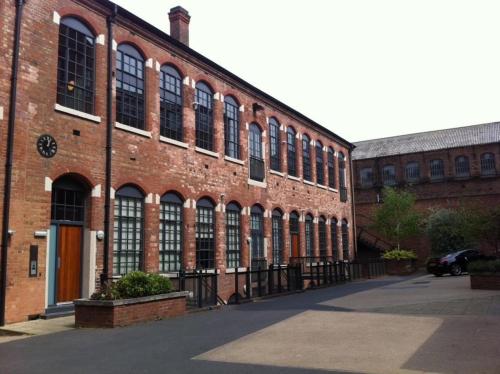 a large brick building with a lot of windows at William Bancroft Apartment in Nottingham