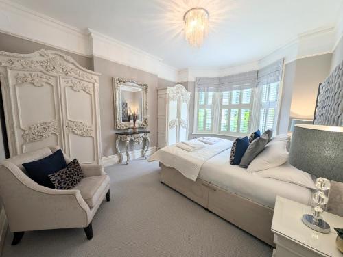 a bedroom with a bed and a chair and a chandelier at South Coast Seaside Holiday Home -3 BED-GF-Sleeps 8-Free Parking-Walk to Beach-Private Garden- Families-Professional Groups-Contractors WELCOME in Bournemouth