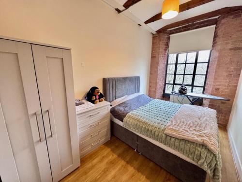 a girl is sitting in a bedroom with a bed at William Bancroft Apartment in Nottingham