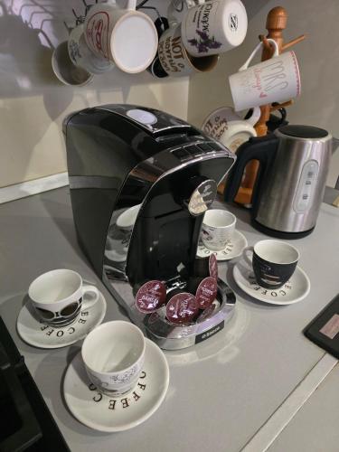 a coffee maker and cups and saucers on a counter at Petra's Skyline in Suceava