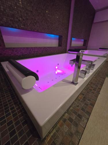 a bath tub with pink lighting on top of it at Petra's Skyline in Suceava