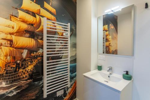 La salle de bains est pourvue d'un lavabo et d'une peinture murale. dans l'établissement Le Jules Verne - Cour et Parking privé, à Amiens