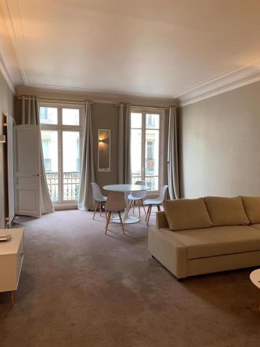 un salon avec un canapé et une table dans l'établissement Executive Apartment - Hotel Particulier, Paris 16, à Paris