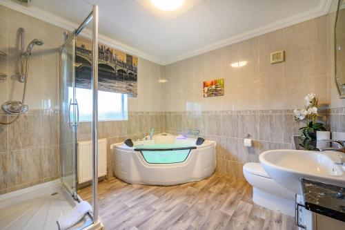 a bathroom with a tub and a sink and a shower at -CH- Stylish & Relaxed Stay,Free Parking,Free WiFi in Batley