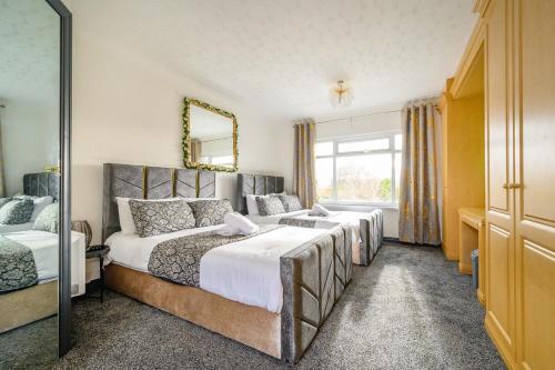 a bedroom with three beds and a mirror at -CH- Stylish & Relaxed Stay,Free Parking,Free WiFi in Batley