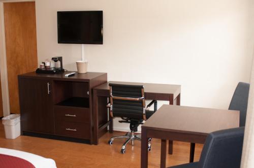 a room with a desk and a tv and a chair at Cambria Palms Motel in Cambria