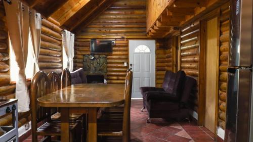a dining room in a log cabin with a table and chairs at Cabañas Rincon del Ángel 2 in Ciénaga