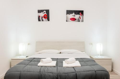 a bedroom with a large bed with two pictures on the wall at casalami in Sanremo