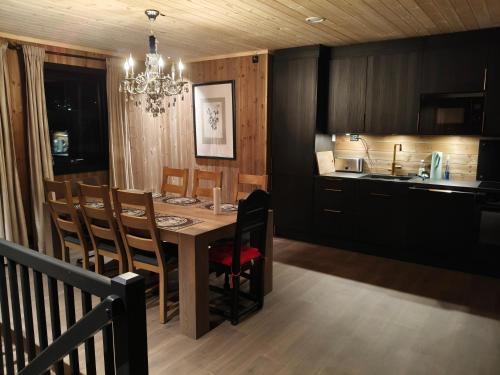 a kitchen and dining room with a table and chairs at Trysil turistesenter hytte in Trysil